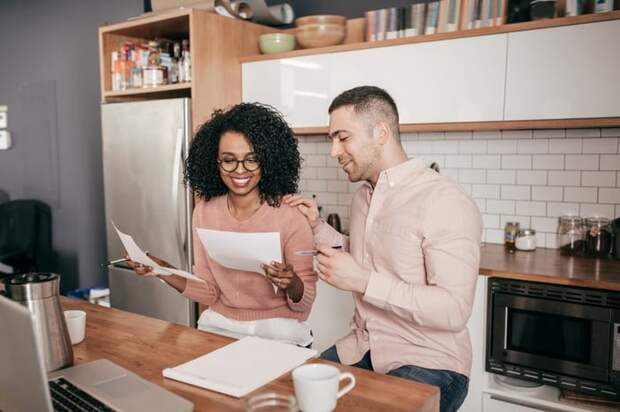 Couple looking over paperwork together in the kitchen.