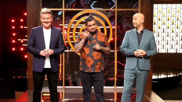 Gordon Ramsay, Aarón Sánchez, and Joe Bastianich stand in front of the MasterChef emblem laughing during the Millennial auditions.