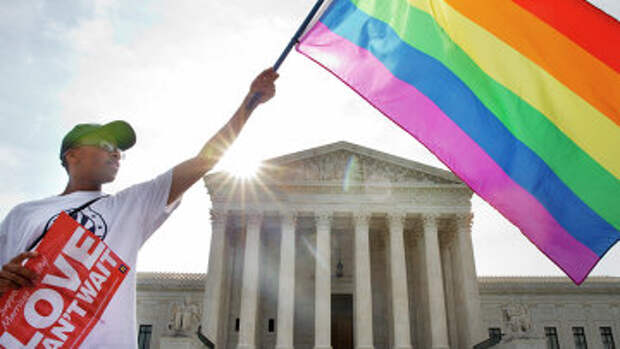 Активист держит флаг ЛГБТ у здания Верховного суда США в Вашингтоне. Архив
