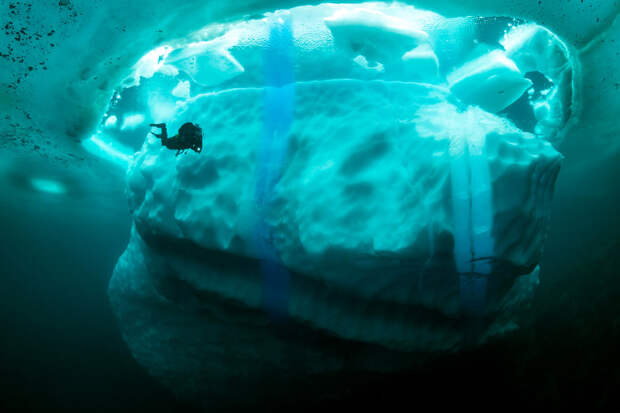 Stunning photos show ice dive beneath giant iceberg