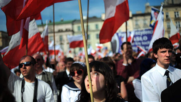 Жители Кракова с польскими флагами на площади города. Архивное фото