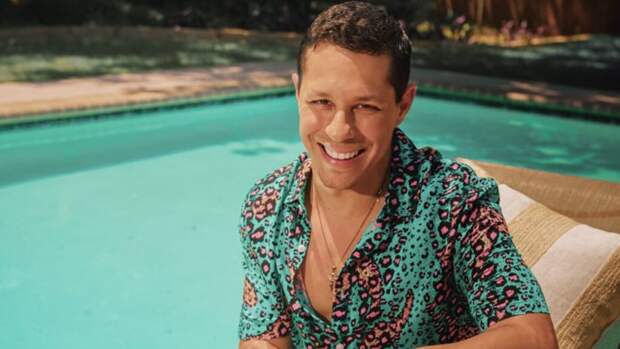 Photo shoot of David Del Rio by an outdoor pool.