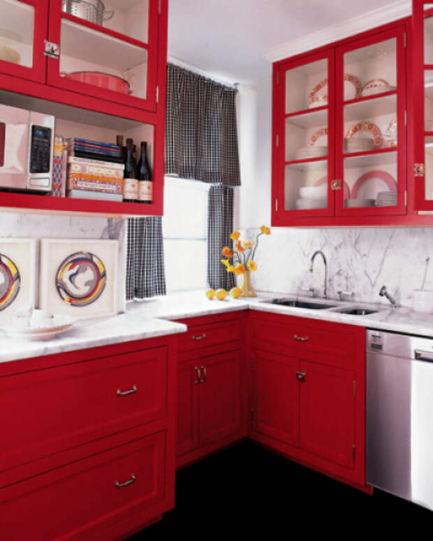 Угловая кухня с красными шкафчиками.