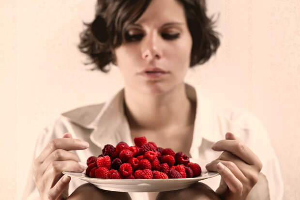 Woman Holding a Bowl of Raspberries