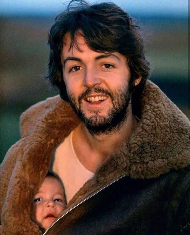 Пол Маккартни позирует со своей дочерью под курткой, 1970-е годы.