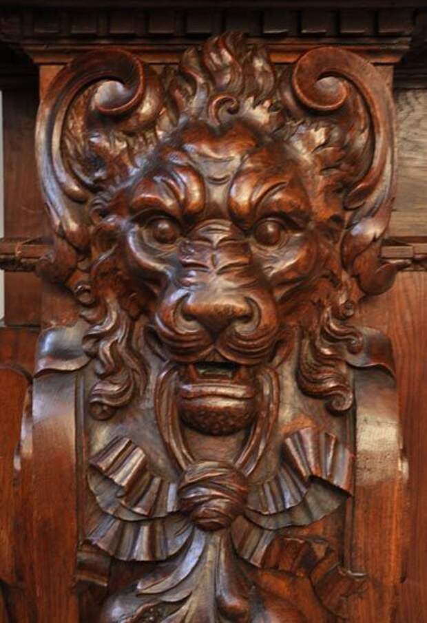 Large antique fireplace with lions heads carved out of oak wood