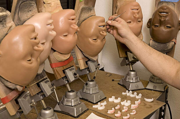 8. Дерек Транк в процессе нанесения косметики на лицо куклы.
