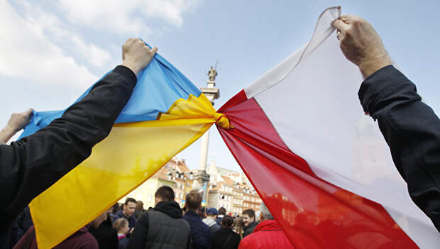 Люди держат связанные флаги Польши и Украины в Варшаве. Архивное фото