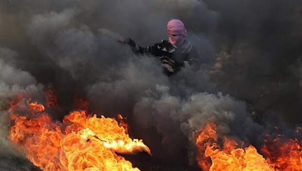Протестующий во время столкновений на границе Палестины и Израиля в районе Рамаллы. 11 декабря 2017
