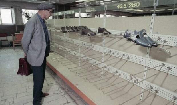 Мужчина разглядывает опустевшие полки обувного отдела в универмаге «Московский», 1990 год. 