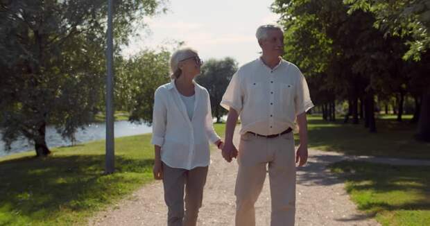 Two people walking and holding hands.