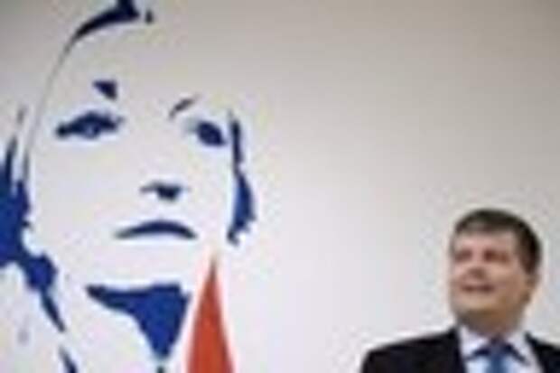 Кандидат на муниципальных выборах на фоне портрета Марин Ле Пен