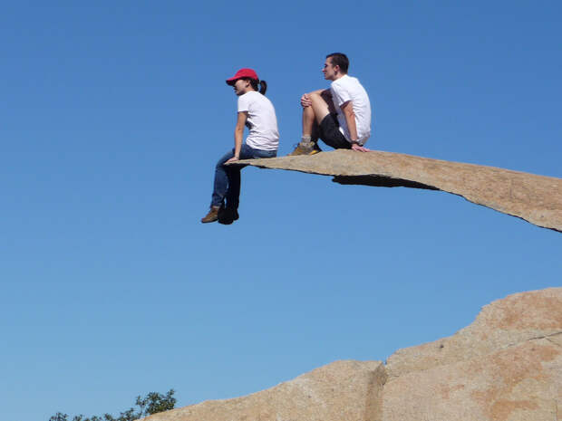 Девушка свесила ноги с Potato Chip Rock 