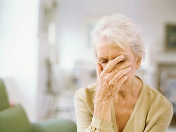 Stressed person with their hand over their face.