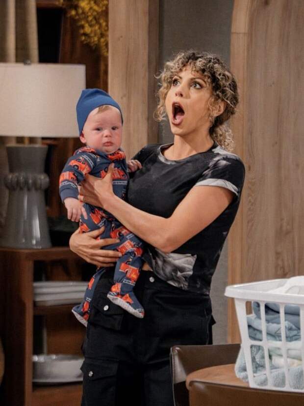 Jess Salgueiro as Eve holds her baby with her mouth open