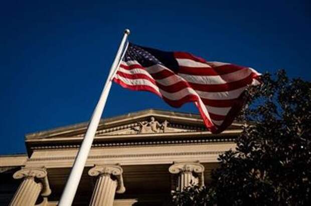 An American flag waves outside the U.S. Department of Justice Building in Washington, U.S., December 15, 2020. REUTERS/Al Drago
