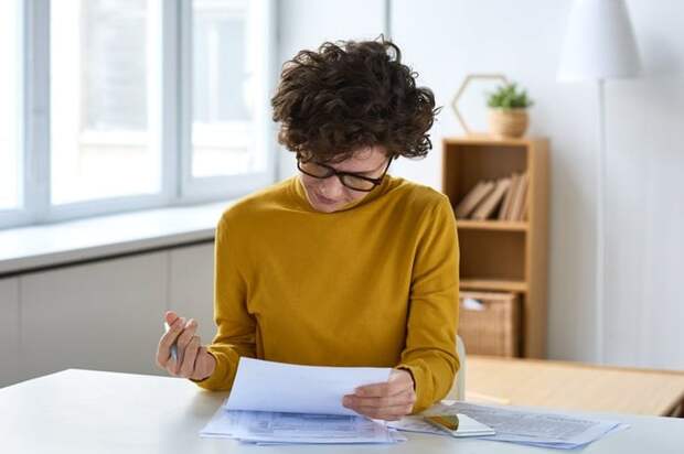 A person sitting at a desk and filling out paperwork.