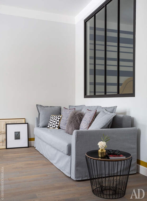 Раскладной диван из IKEA дополнен подушками, Oka, Zara Home и Ferm Living. Журнальный столик, ComingB. Межкомнатное окно сделала компания “Метэкс”.