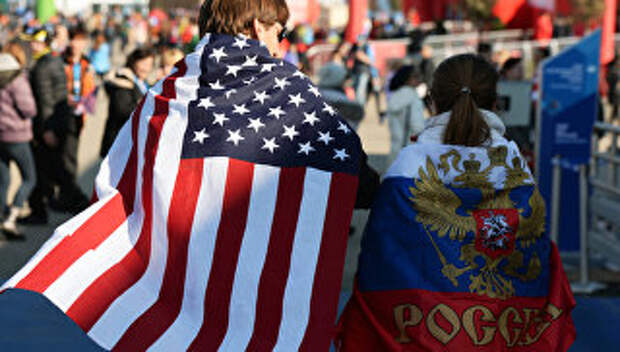 Молодые люди в национальных флагах США и России