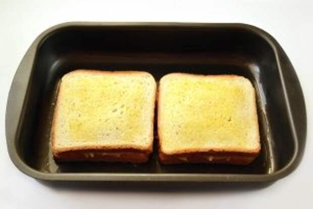 Два оставшихся кусочка хлеба кладём сверху так, чтобы сторона, намазанная горчицей, совместилась с сыром. Верхушку намазываем оливковым маслом. Запекаем при 180°C до золотистого цвета.