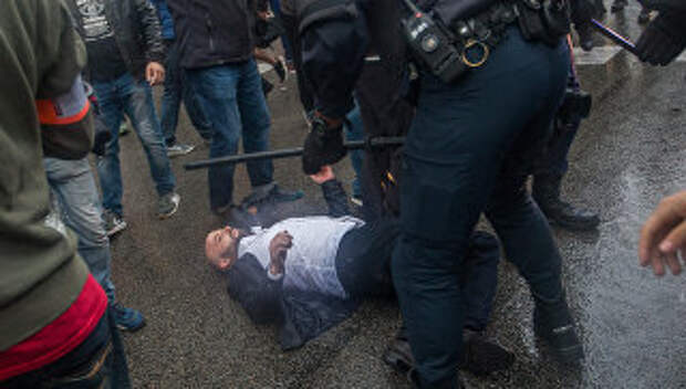 Сотрудники полиции задерживают участников столкновений у избирательных участков в ходе референдума о независимости Каталонии. 1 октября 2017