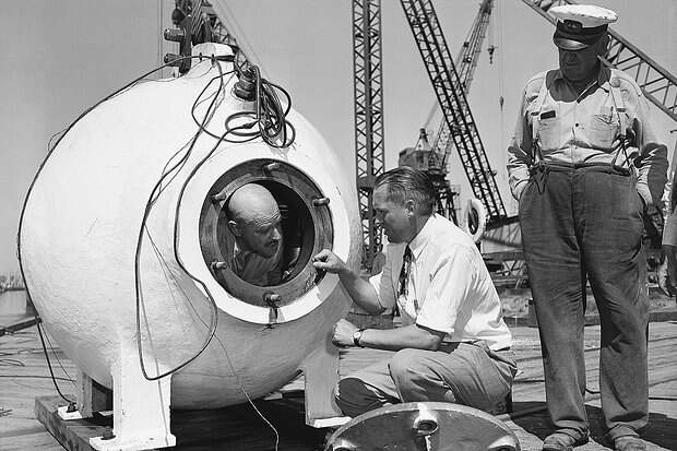 Otis Barton, who descent 3,028 feet in Beebe's bathysphere in 1934 off Bermuda, gets some final instruction from Dr. Maurice Nelles before being sealed into the bell of the University of Southern California Benthoscope at Long Beach, Calif.