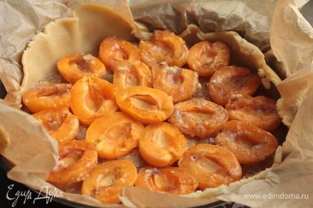 Поверх теста выложите франжипановую начинку и сверху расположите абрикосы.