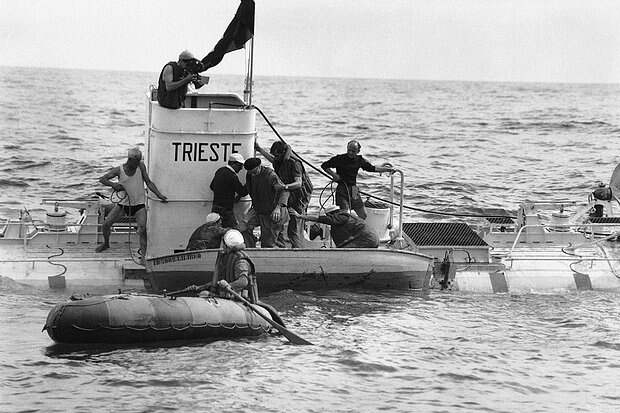 Jacques Piccard, wearing life jacket at right center, assists his father, Prof. Auguste Piccard, wearing beret, center, out of turret of their steel diving boat, the bathyscafe Trieste, near the island of Ponza in Italy on Sept. 30, 1953. The two scientists descended in their craft to a record 10,339 feet below the surface of the Tyrrenhian Sea. They are assisted by seamen from an Italian corvette which acted as their escort. They described the depths as a grave-like calm and Stygian blackness broken only by ghostly flickers of phosphorescence hinting at unknown forms of life. (AP Photo/Walter Attenni)