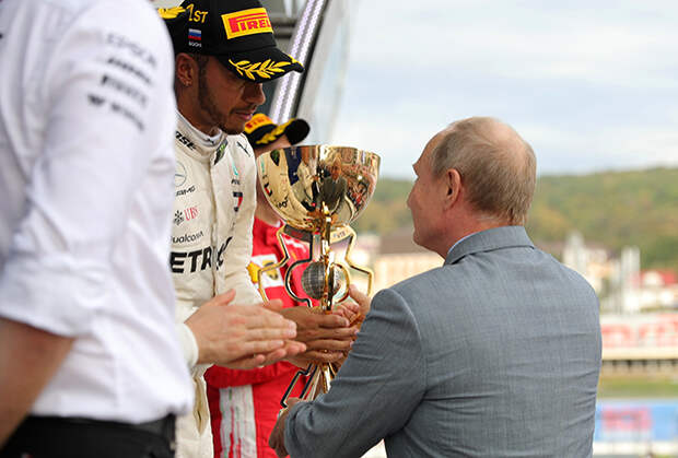 Президент России Владимир Путин вручает победный кубок Льюису Хэмильтону. 