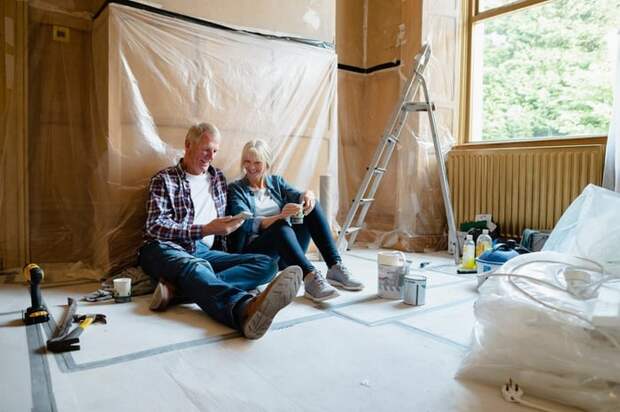 Couple sitting relaxing in a room that's undergoing renovation.