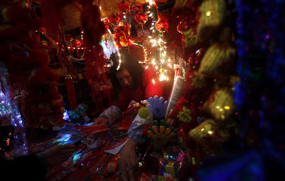 217615 a vendor stands inside her shop selling chinese new year products at a Подготовка к китайскому Новому году Дракона