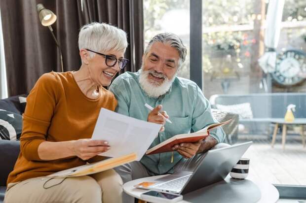 Two people on a couch reviewing documents.