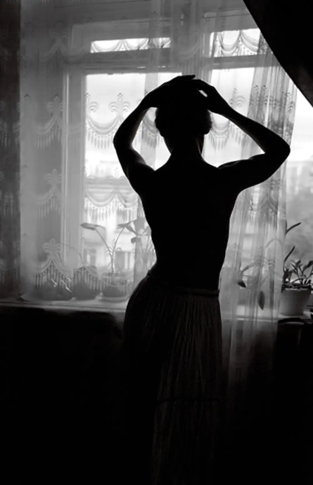 Девушка у окна со спины