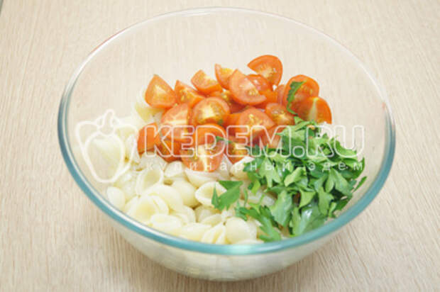 Переложить макароны в миску и добавить помидорчики черри и зелень.
