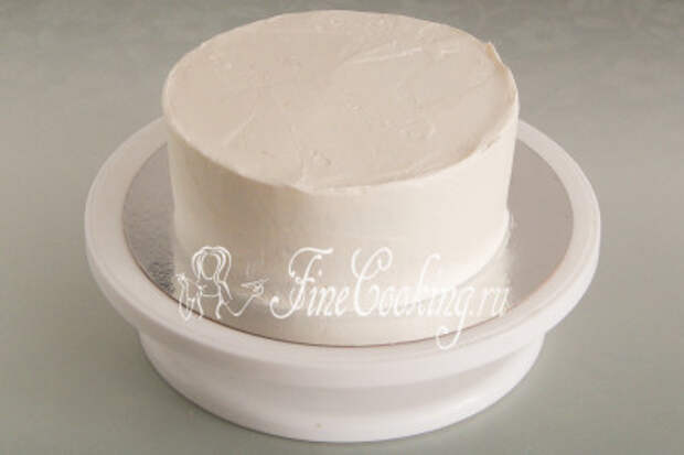 Покрываем застывший торт еще одной частью крема и выравниваем его: бока и верх
