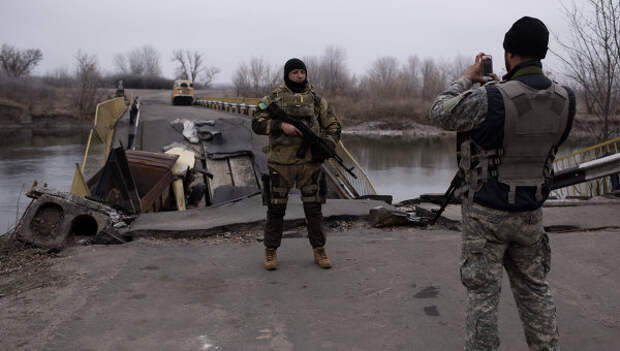 Украинские военные фотографируются на фоне разрушенного моста через реку Северский Донец Украинские военные фотографируются на фоне разрушенного моста через реку Северский Донец