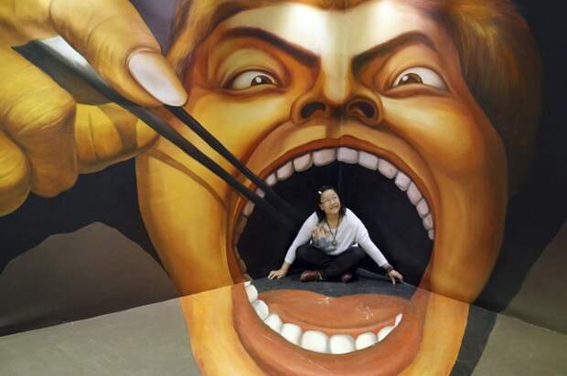A woman poses for a photograph in front of a 3D painting at an exhibition in Guiyang, China on April 14, 2013. (Reuters photo)