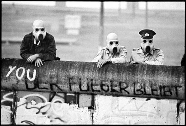 Восточногерманские пограничники наблюдают за разгоном демонстрантов с помощью слезоточивого газа по другую сторону берлинской стены, 1988 год. история, ретро, фото