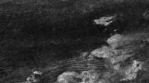 Таинственные ураганы Титана Титан покрыт реками и озерами метана, которые расположены у величественных гор и окружены дюнами. Именно эти дюны и удивили наши астрономов: по все признакам, они должны вытягиваться в сторону запада, но в реальности дюны стремятся к востоку. Сравнительно недавно физики объяснили, в чем дело — метановые бури на Титане настолько сильны, что буквально продавливают поверхность планеты.