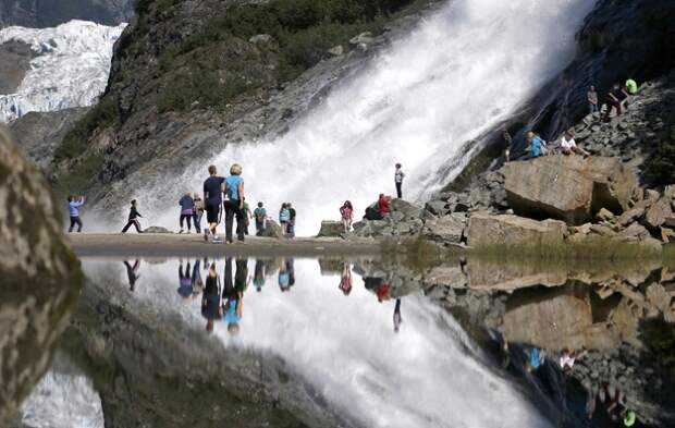 Туристы и их отражение на леднике Менденхолл.