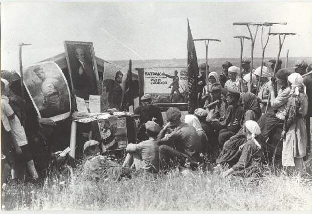 Беседа с крестьянами. Надпись на центральном плакате: «Батрак во главе бедноты и середняков иди в колхоз». 1931