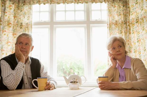 Two people sitting at a table looking away from each other.
