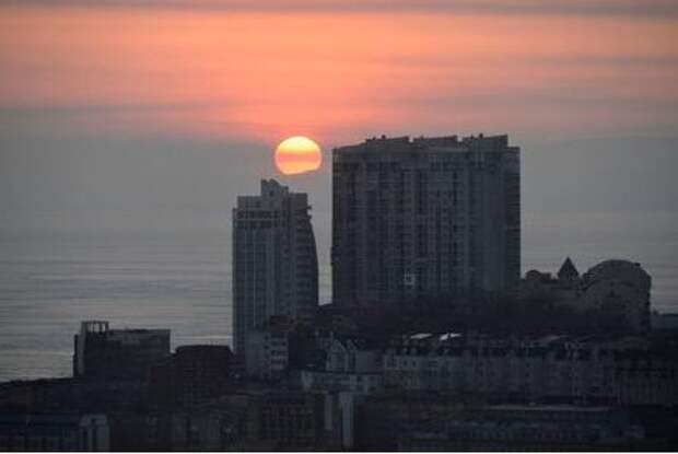 The sun sets over residential buildings in the city of Vladivostok, Russia February 19, 2018. REUTERS/Yuri Maltsev
