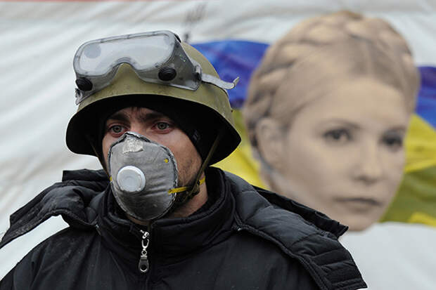 Евромайдан. Протестующий в респираторе на фоне портрета Юлии Тимошенко на Майдане Незалежности (площадь Независимости).
