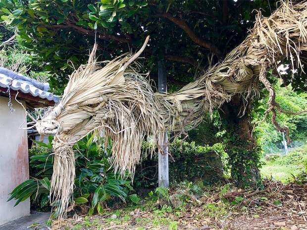 Скульптура гигантского японского дракона из листьев пальмы и дерева 