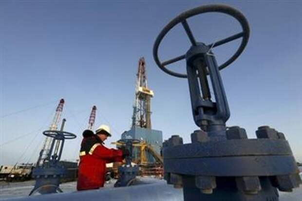 A worker checks a valve of an oil pipe at the Lukoil company owned Imilorskoye oil field outside the West Siberian city of Kogalym, Russia, in this January 25, 2016 file photo. REUTERS/Sergei Karpukhin/Files TPX IMAGES OF THE DAY