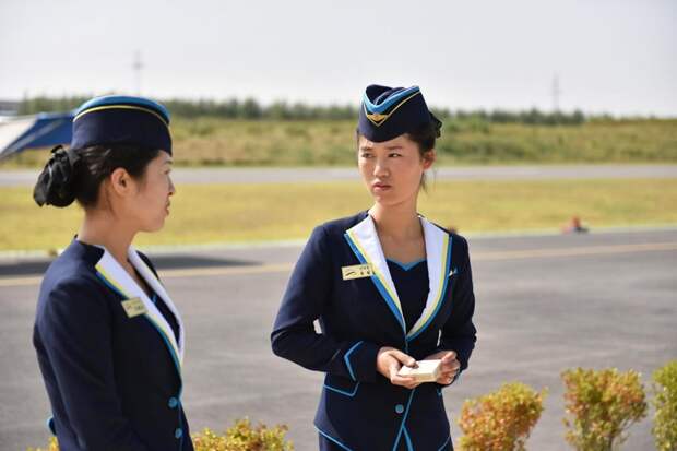 Две сотрудницы лётного клуба стоят около взлётной полосы Арам Пан, Пхеньян, видео, красота, редкие кадры, с высоты, фотограф