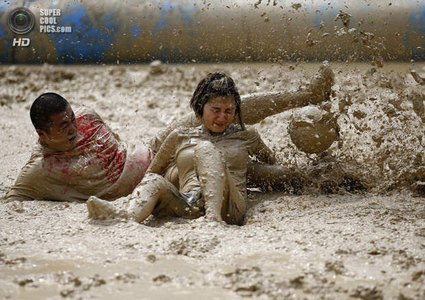 Китай. Пекин. 26 июня. Во время турнира по футболу в грязи. (REUTERS/Kim Kyung-Hoon)