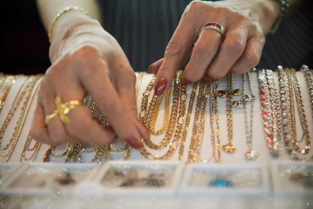 A worker shows gold necklaces in a gold jewellery shop in Bangkok on 17 April, 2013. Gold prices clawed back some losses on April 16 after suffering their heaviest slump in 30 years owing to weak Chinese growth data and reports that Cyprus was planning to sell some of its reserves of the precious metal. AFP PHOTO / Nicolas ASFOURI (Photo credit should read NICOLAS ASFOURI/AFP/Getty Images)