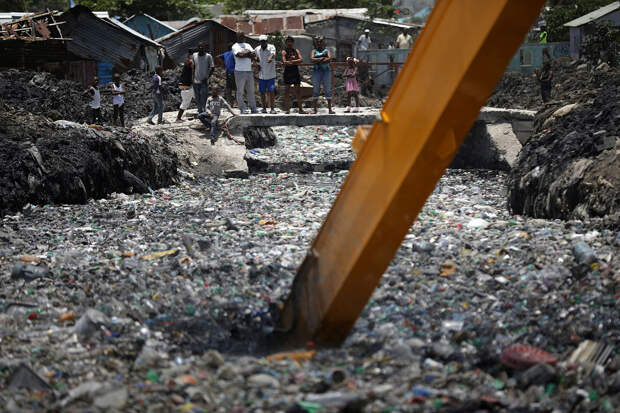 Экскаватор пытается очистить реку от пластика под Порт-о-Пренс, Гаити